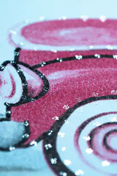 Extreme close-up of red vintage car showing glitter texture and embossed detail on blue wallpaper