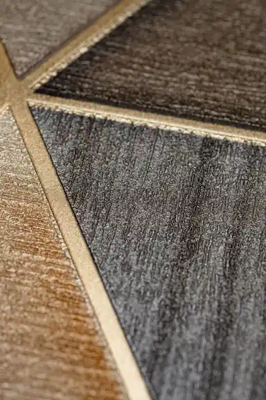 Extreme close-up macro of embossed triangle wallpaper showing textured bronze and gold surfaces
