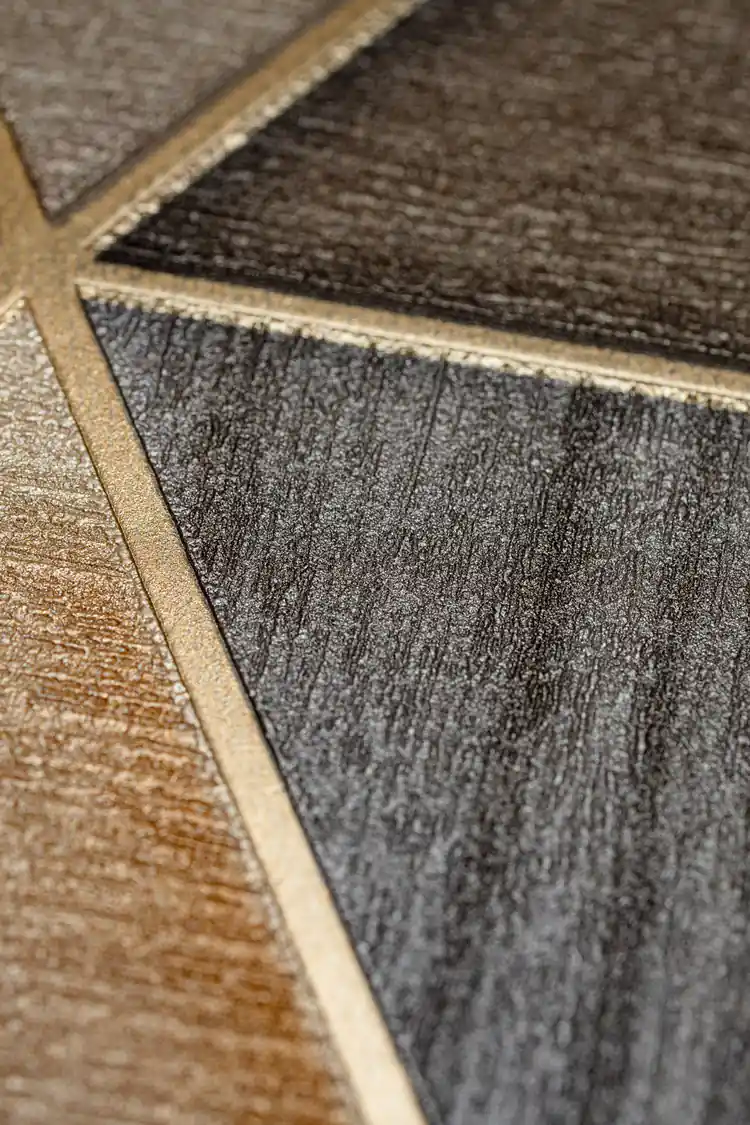 Extreme close-up macro of embossed triangle wallpaper showing textured bronze and gold surfaces