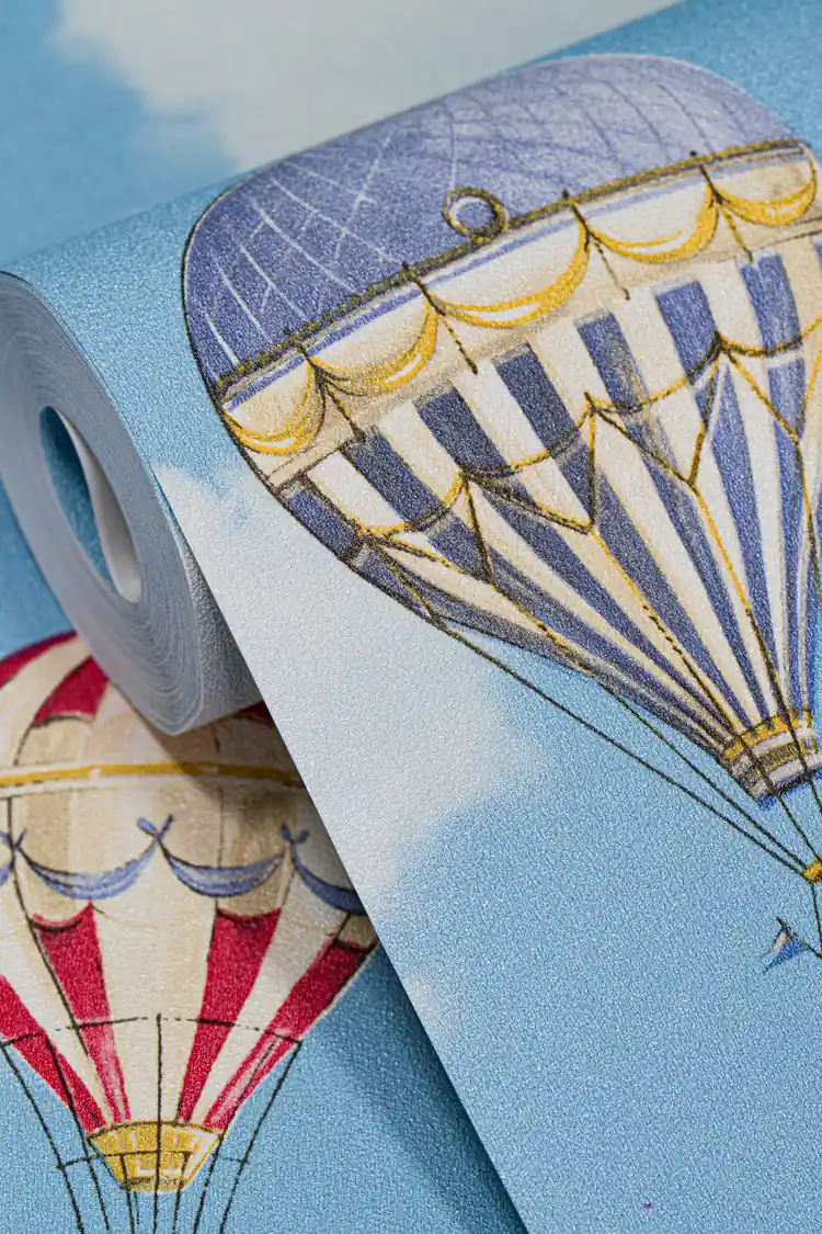 Wallpaper roll close-up showing blue and red hot air balloons on bright blue sky with clouds