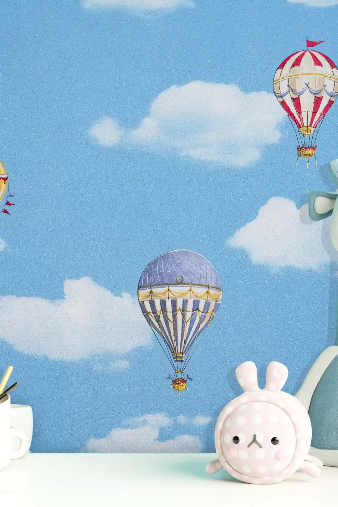 Close-up of blue sky wallpaper with hot air balloons and soft toys on a shelf