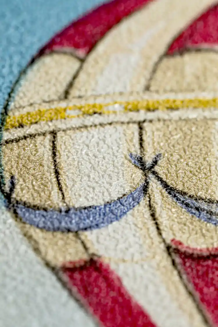 Extreme close-up macro of hot air balloon envelope texture showing embossed fabric detail on blue wallpaper