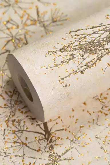 Cream wallpaper roll with gold glitter winter branch patterns and sparkling berry details on a warm beige base