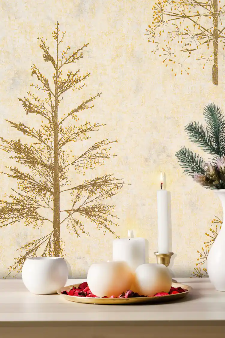 Close-up of gold glitter pine tree on cream wallpaper with white candles and festive decor