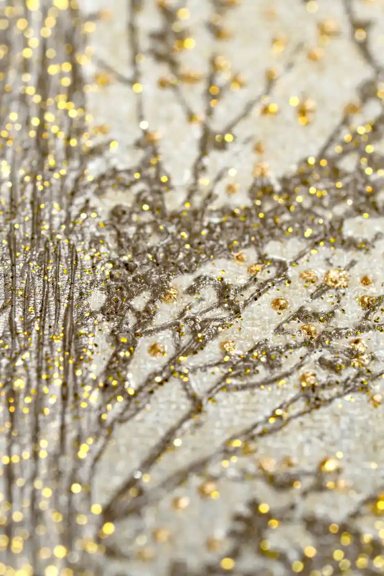 Extreme close-up macro of gold glitter particles on pine tree branches showing sparkle texture