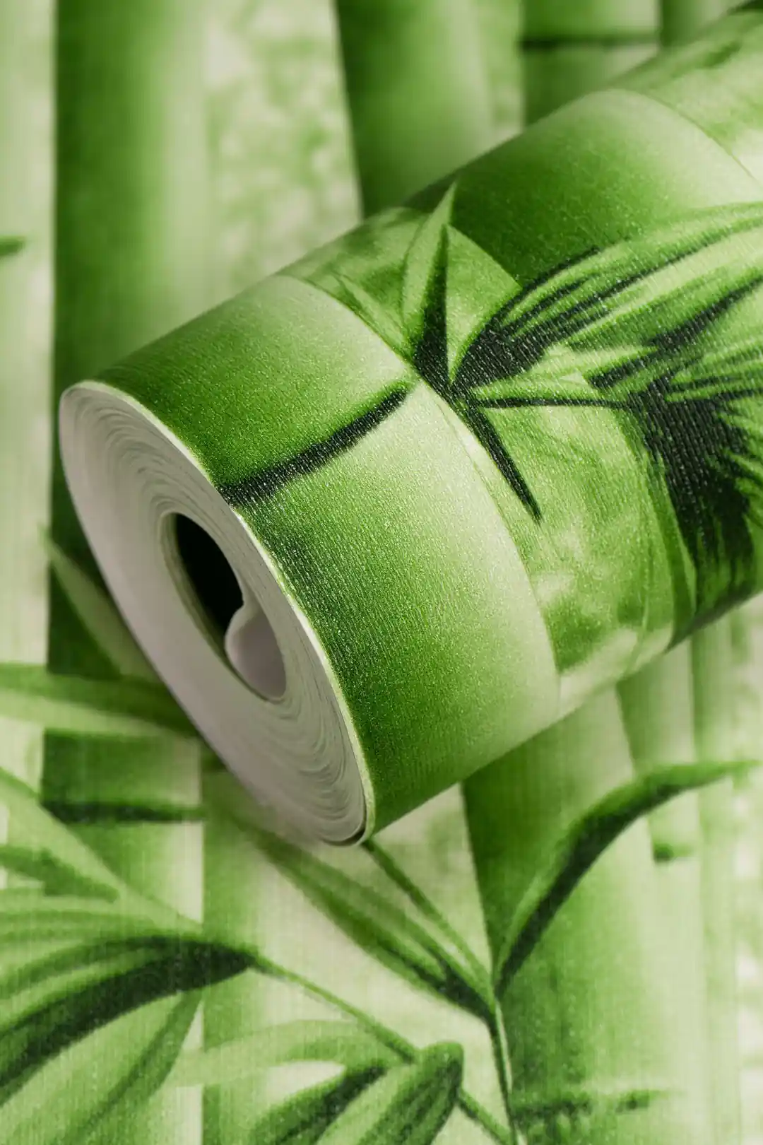 Close-up of a rolled green bamboo wallpaper showing bamboo stalks and leaf print detail