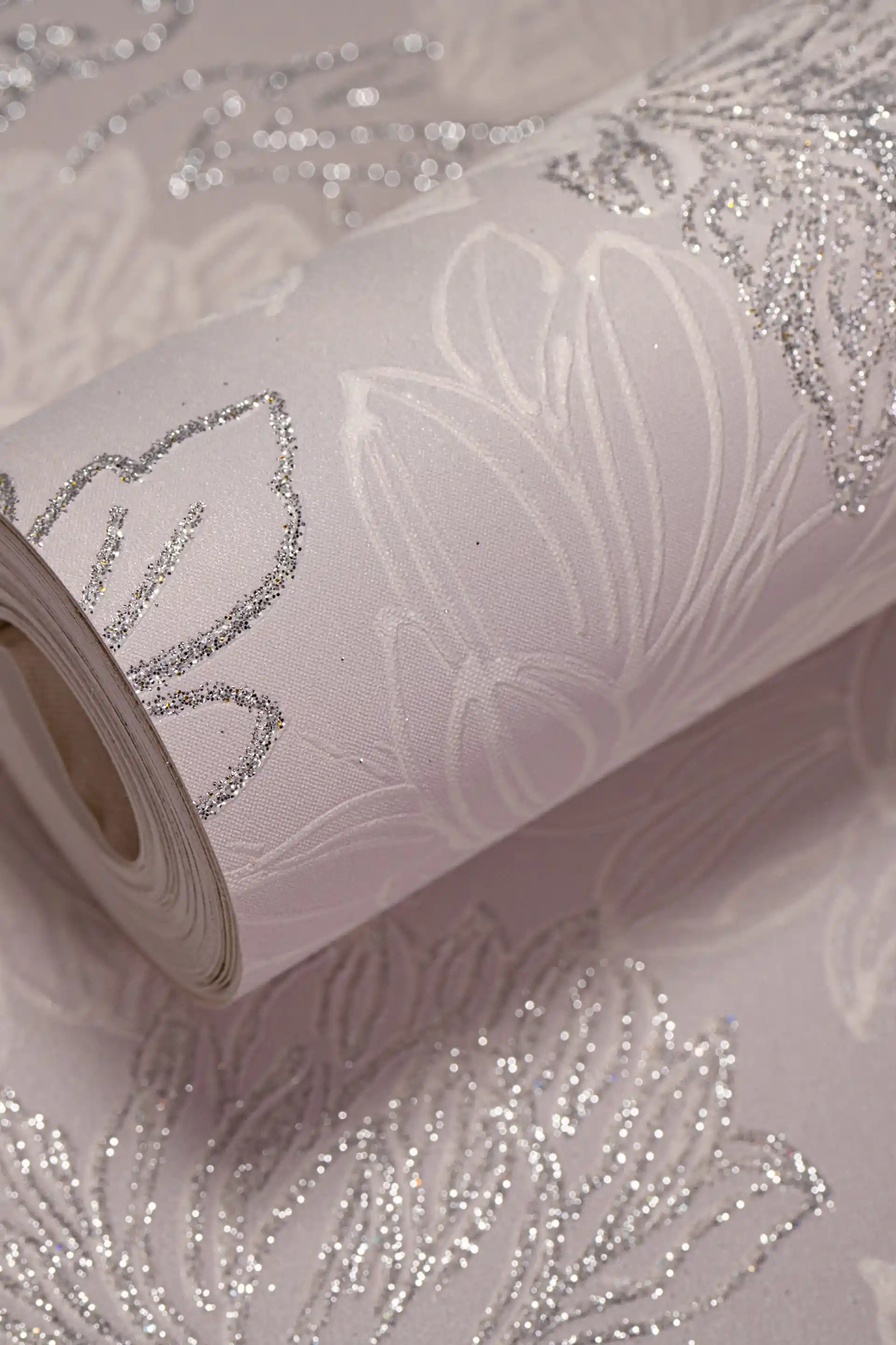 Soft pink chrysanthemum wallpaper roll with silver glitter floral accents on a delicate blush background
