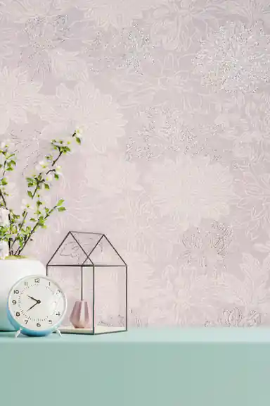 Installed blush floral wallpaper with silver glitter chrysanthemums behind a mint shelf with clock and decor