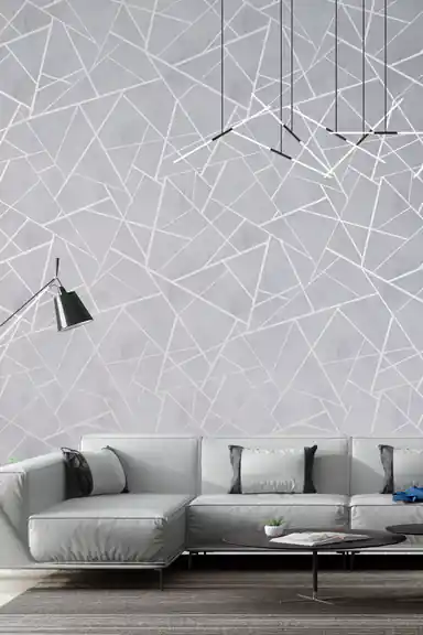 Modern living room with gray geometric wallpaper featuring silver lines behind a minimalist sofa and pendant lights