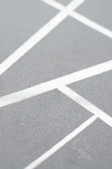 Extreme close-up of gray wallpaper texture with embossed metallic silver angular line pattern