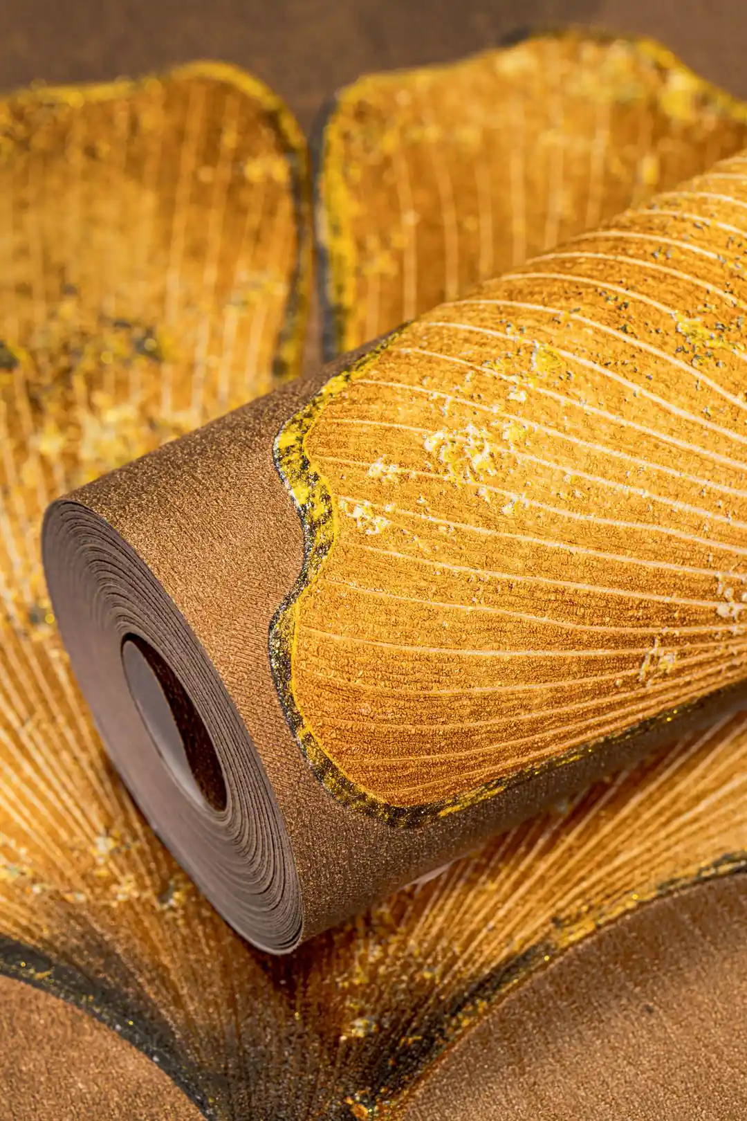 Living room setting with installed gold ginkgo leaf wallpaper on wall with a cactus plant on a green desk