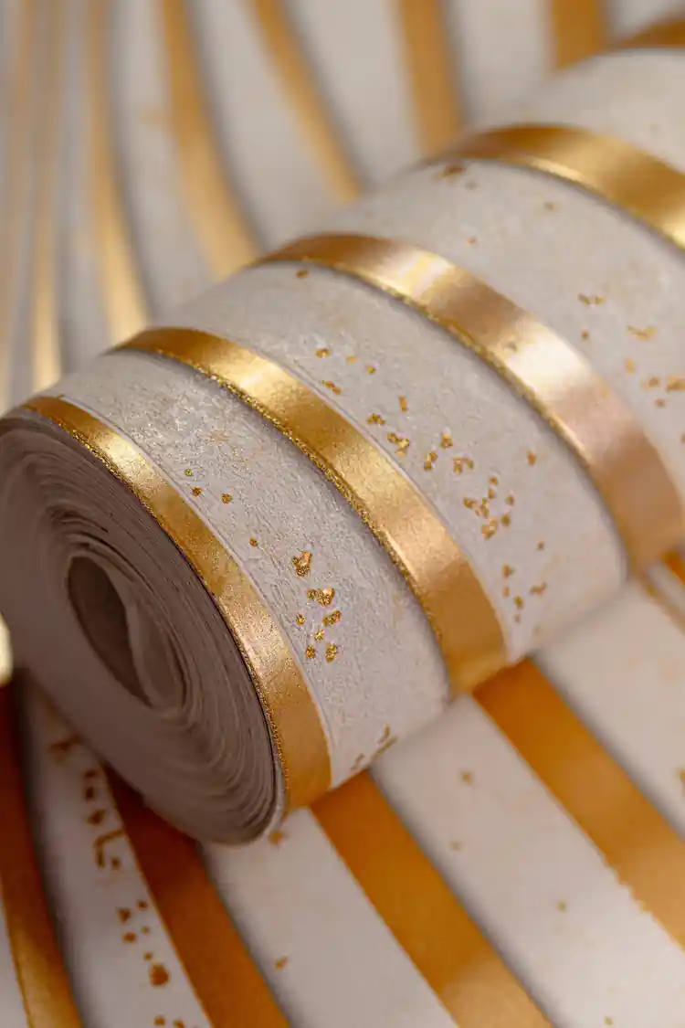 Cream wallpaper roll with 3D gold wavy stripes and metallic shimmer on a white textured background