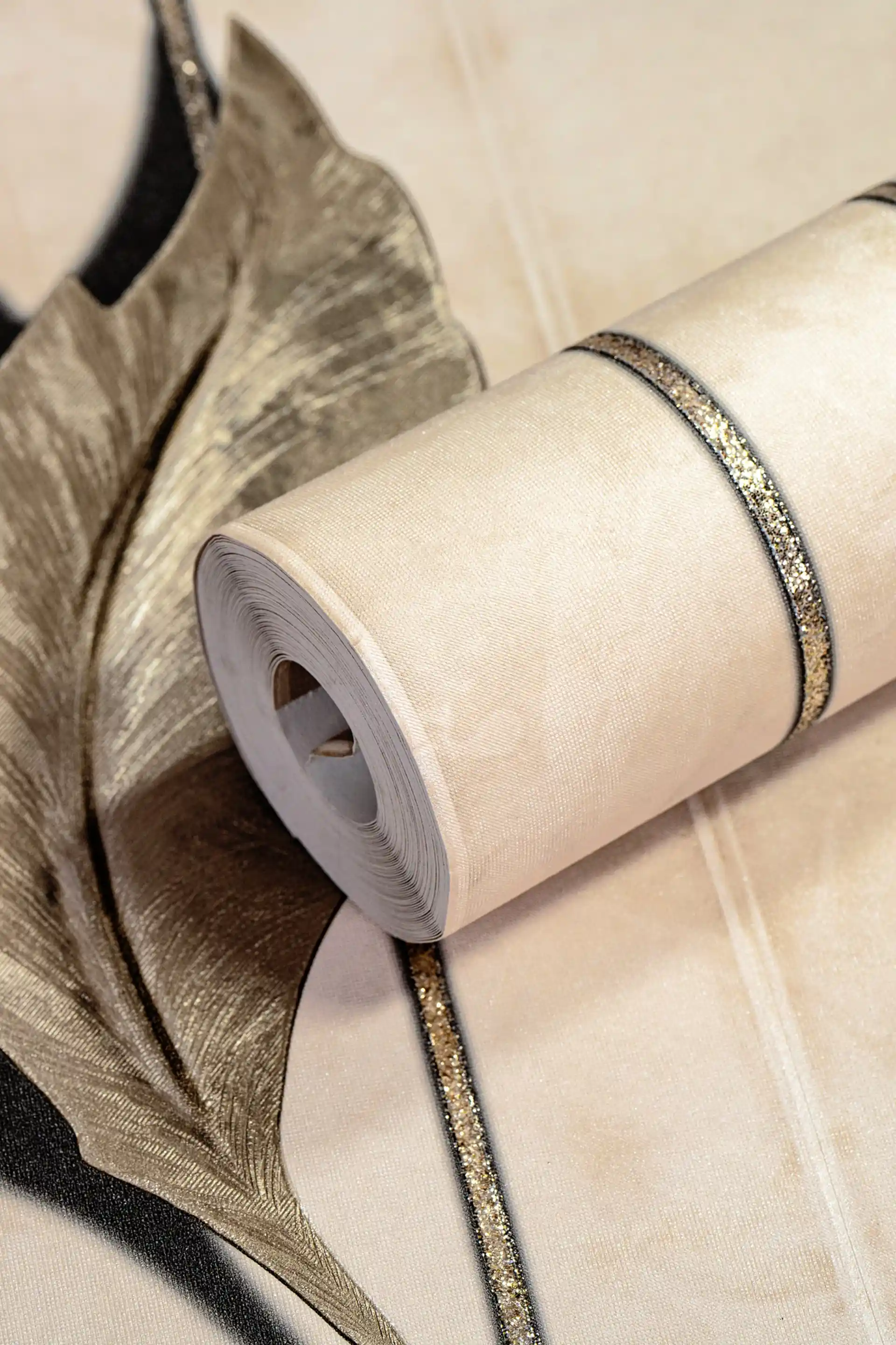 Cream wallpaper roll with 3D floating leaves and silver glitter stripes on a warm beige background