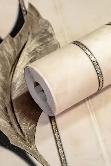 Cream wallpaper roll with 3D floating leaves and silver glitter stripes on a warm beige background