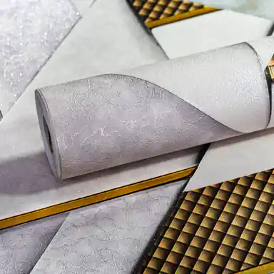 White and grey geometric wallpaper roll with metallic gold grid lines and 3D triangular pattern design