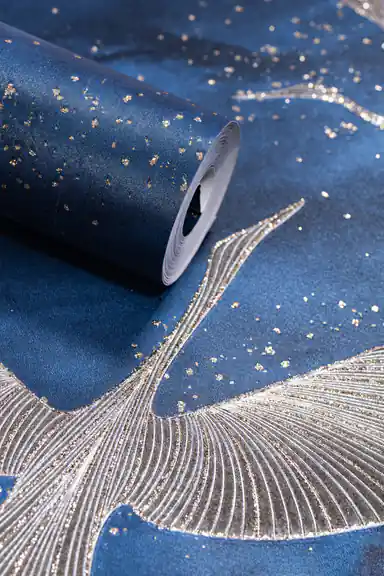 Deep blue wallpaper roll with silver and gold flying crane birds and scattered glitter on navy background