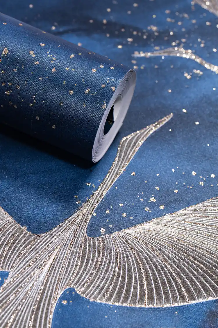 Deep blue wallpaper roll with silver and gold flying crane birds and scattered glitter on navy background