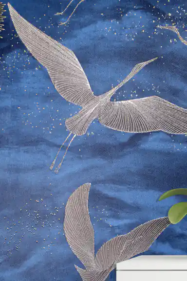 Close-up of silver flying crane with detailed wing lines and gold sparkle on deep blue wallpaper