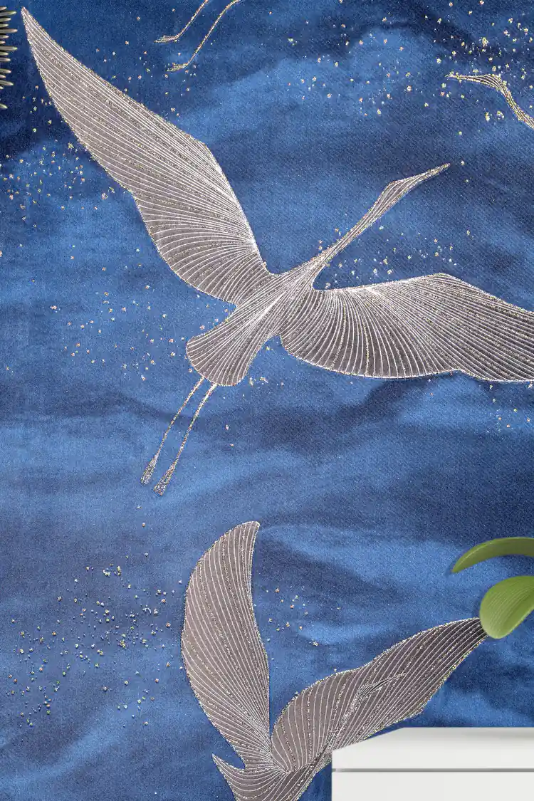 Close-up of silver flying crane with detailed wing lines and gold sparkle on deep blue wallpaper
