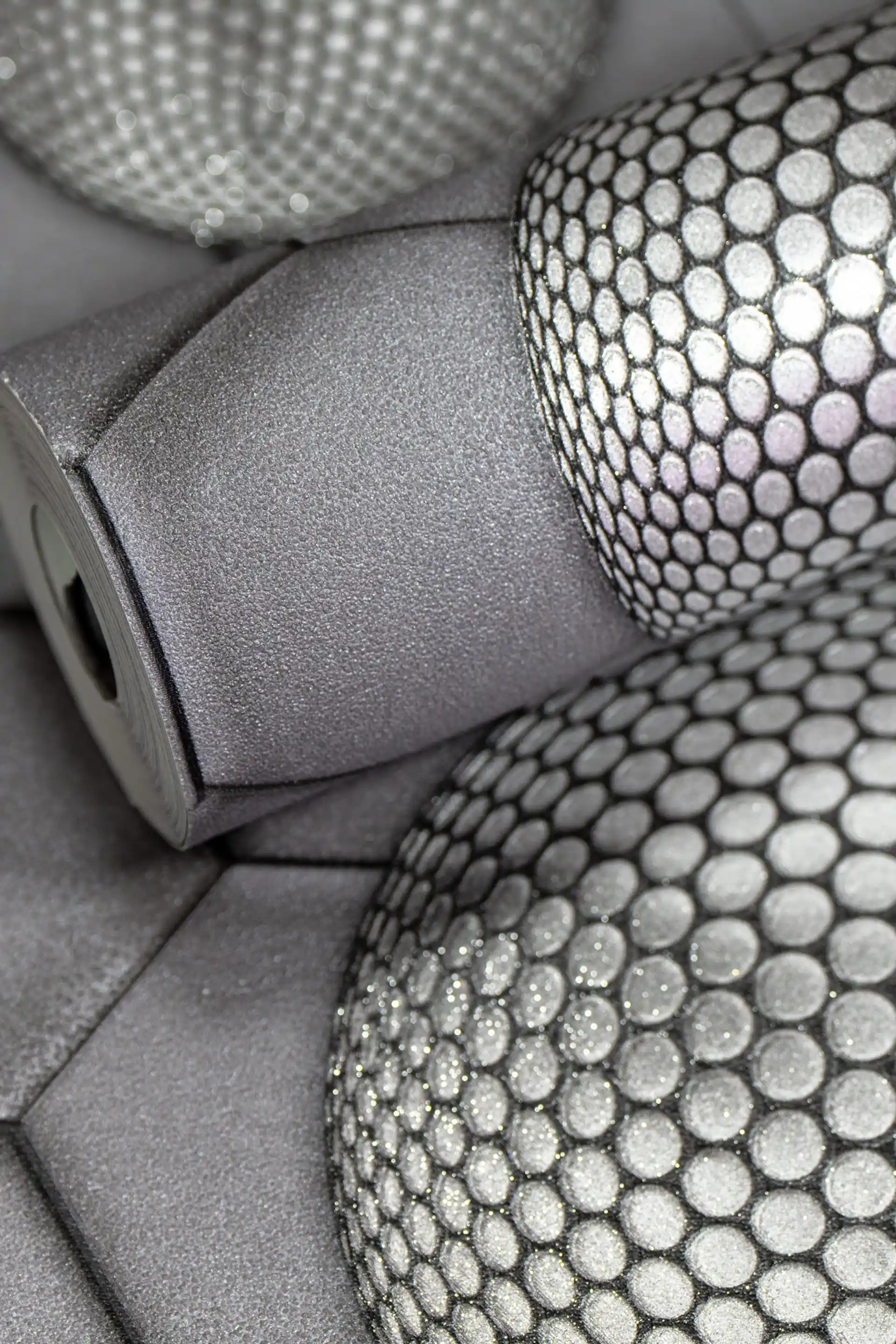 Rolled grey 3D hexagon wallpaper with textured metallic spheres covered in dotted pattern