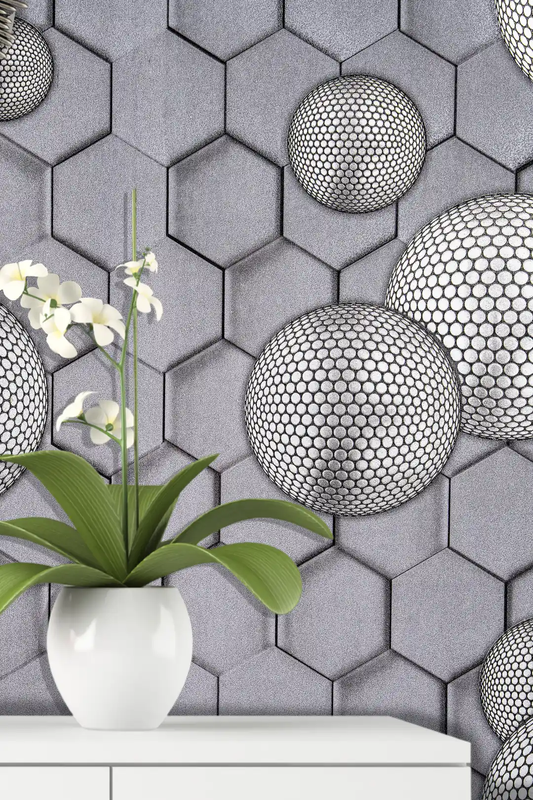 Installed wall view of grey hexagonal wallpaper with dotted spheres next to a white orchid on a shelf