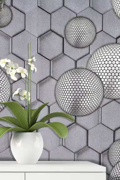 Installed wall view of grey hexagonal wallpaper with dotted spheres next to a white orchid on a shelf