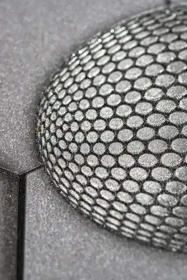 Extreme close-up showing embossed hexagonal texture detail of a single sphere on dark grey wallpaper