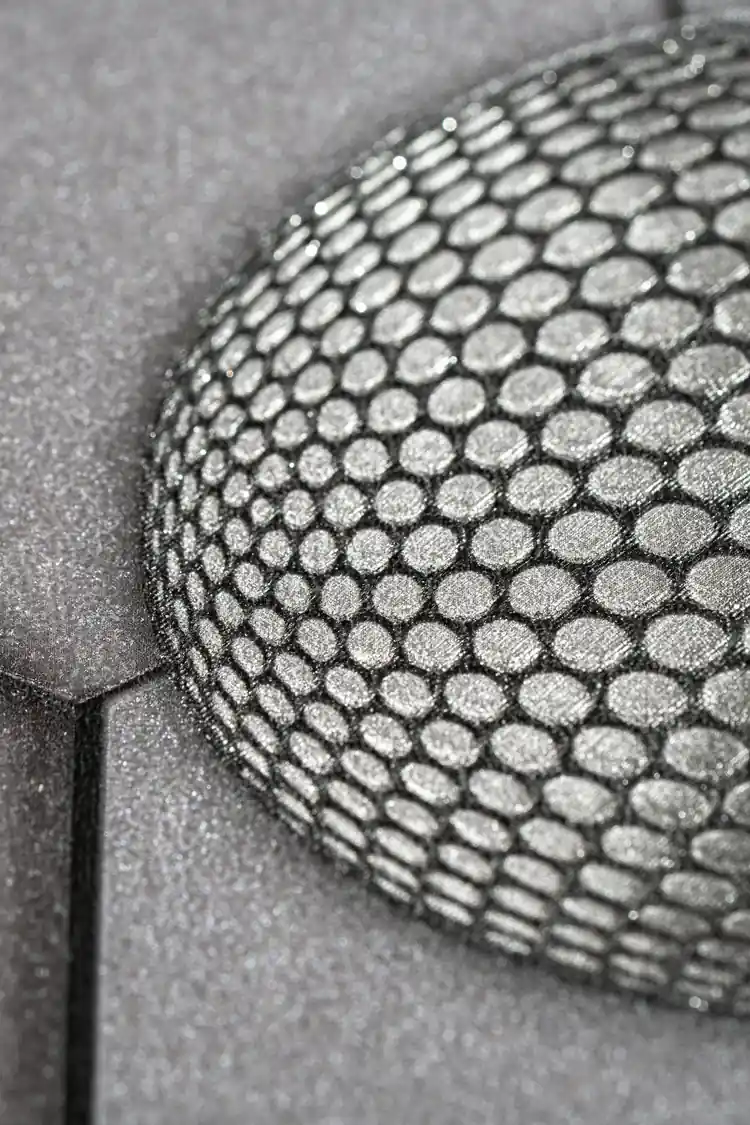 Extreme close-up showing embossed hexagonal texture detail of a single sphere on dark grey wallpaper