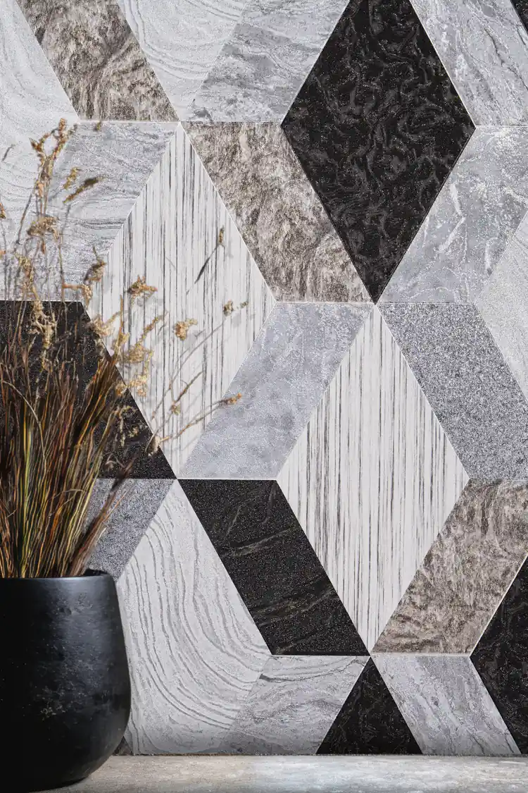 Installed view of geometric marble tile wallpaper with grey and black diamond shapes beside a dark vase