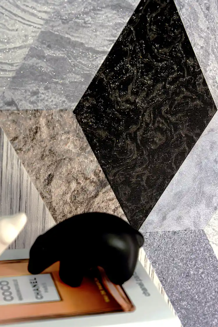 Close-up of diamond-shaped marble tile wallpaper showing black and grey textures with silver glitter accents