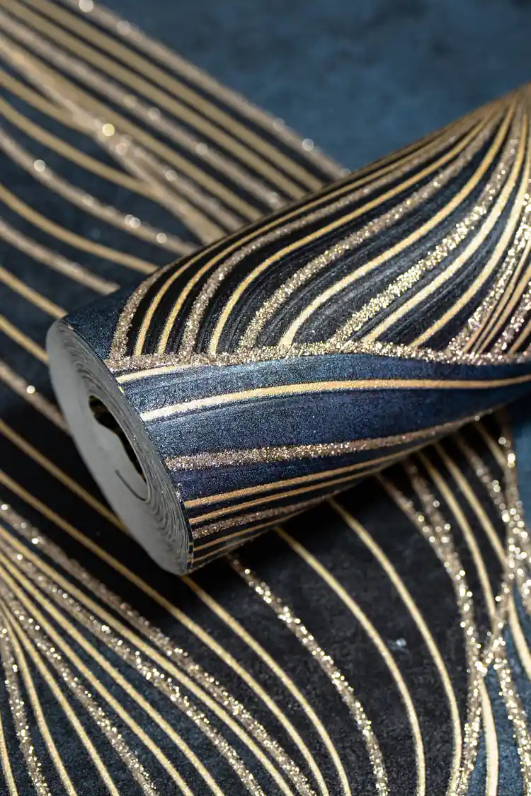 Rolled dark navy wallpaper with flowing gold swirl lines and glitter accents on textured blue surface