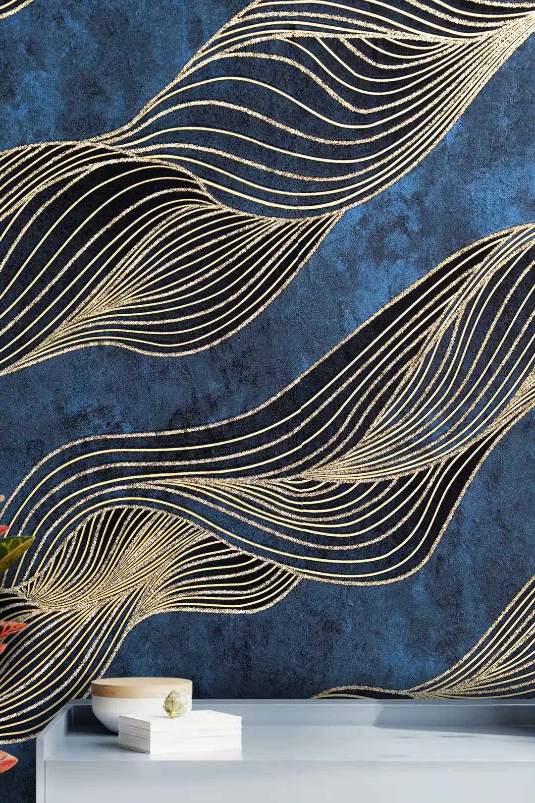 Installed wall showing gold swirl waves on navy wallpaper with a white shelf and minimalist decor below