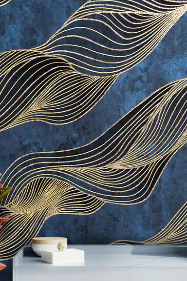 Installed wall showing gold swirl waves on navy wallpaper with a white shelf and minimalist decor below