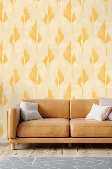 Gold abstract petal wallpaper on cream background installed in a living room with cognac leather sofa and neutral cushions