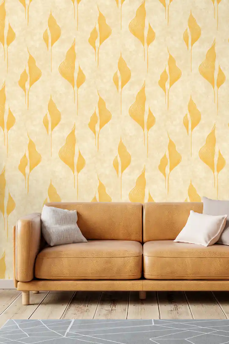 Gold abstract petal wallpaper on cream background installed in a living room with cognac leather sofa and neutral cushions