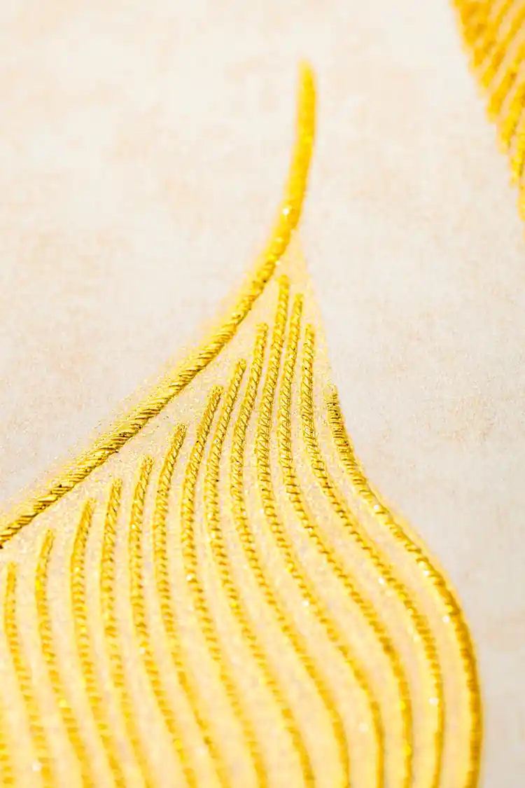 Extreme close-up macro of a single gold embossed calla lily petal showing ribbed texture and glitter