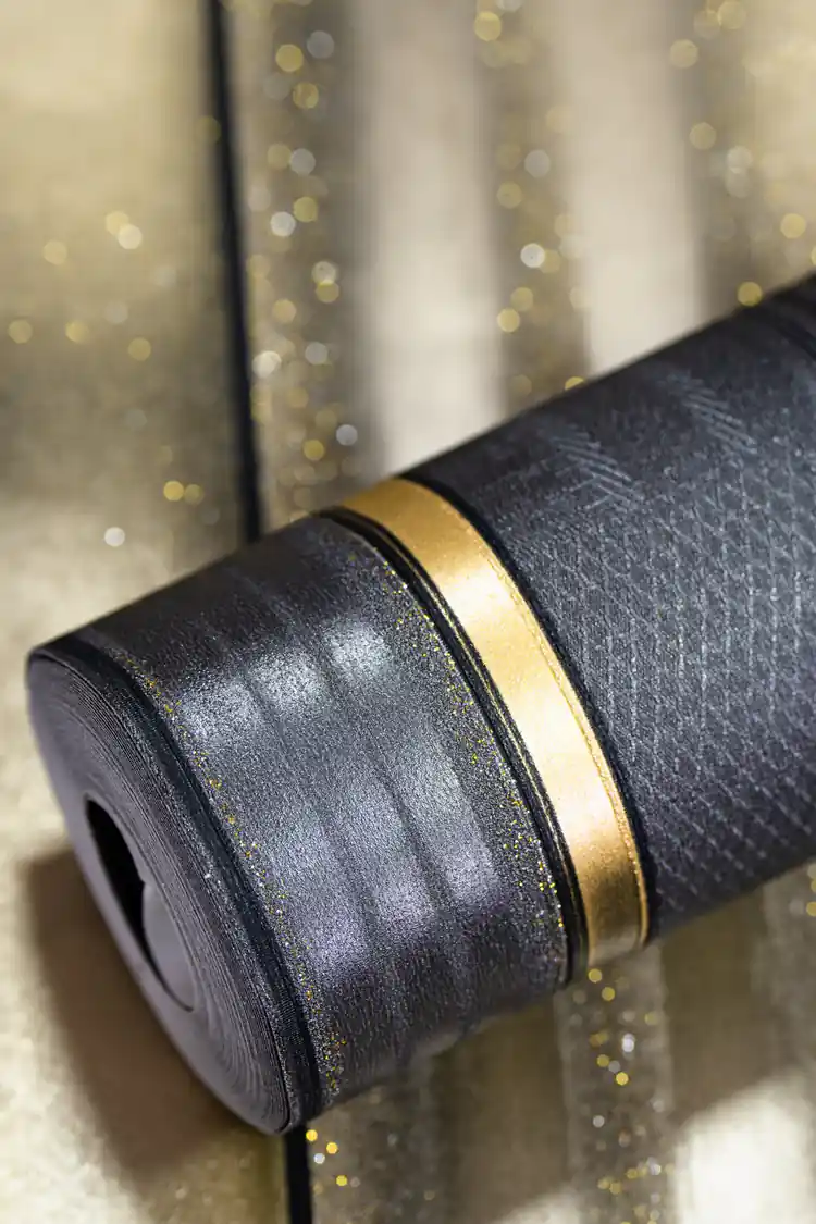 Rolled dark charcoal grey wallpaper with gold metallic panel accents and textured stripe pattern