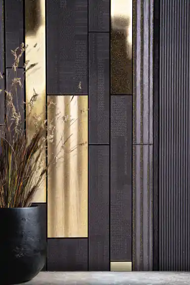 Close-up of dark charcoal wallpaper with gold metallic rectangular panels and dried flowers in black vase