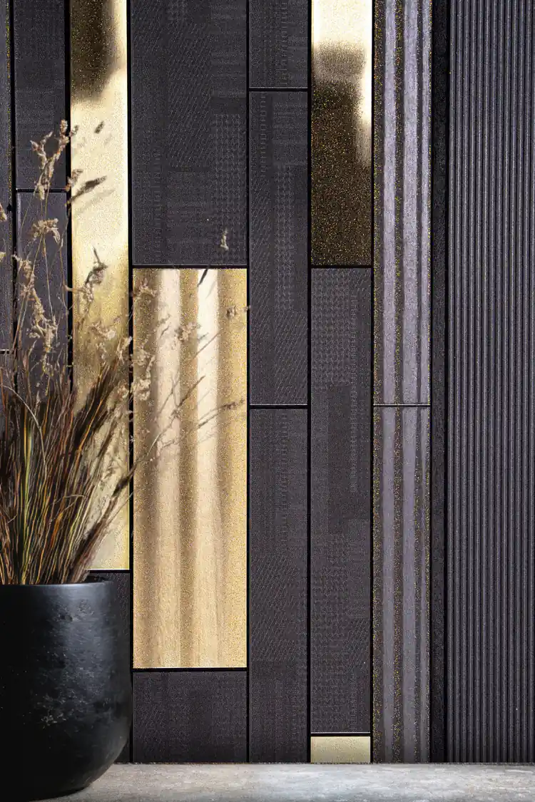 Close-up of dark charcoal wallpaper with gold metallic rectangular panels and dried flowers in black vase