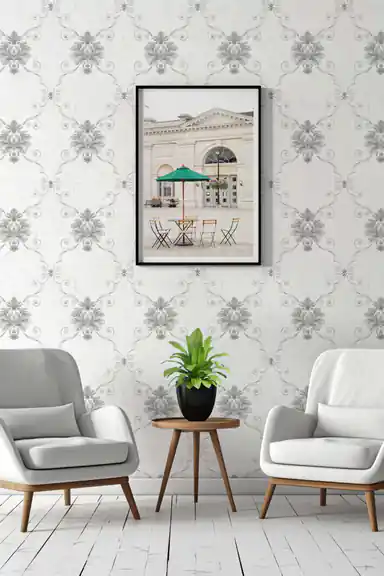 Silver damask wallpaper in an elegant sitting room with grey armchairs, potted plant, and framed wall art