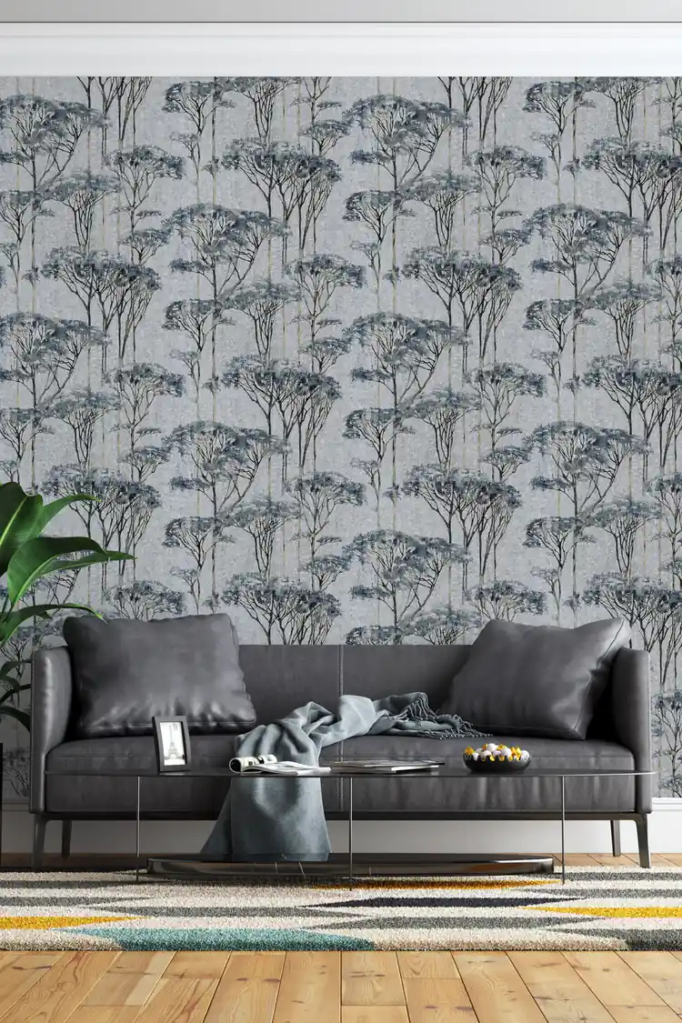 Blue and grey forest trees wallpaper installed in a living room with dark leather sofa and modern decor