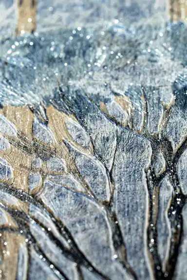 Extreme close-up macro of textured tree foliage with gold glitter particles on blue-grey wallpaper
