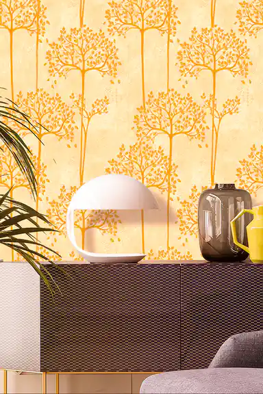 Yellow and golden tree pattern wallpaper with detailed leaf canopies installed in a living room with dark chevron sideboard and dome lamp