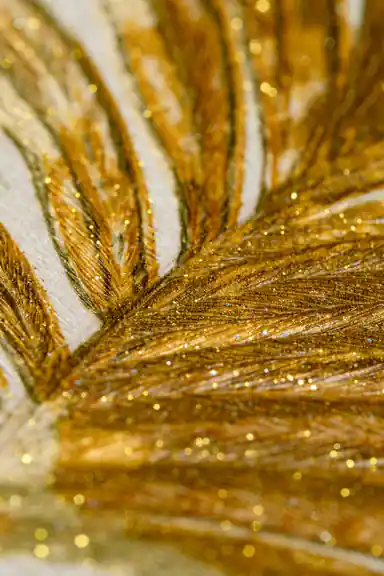 Extreme close-up macro showing embossed golden palm frond texture with glitter sparkle detail on wallpaper