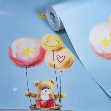 Rolled light blue kids wallpaper with cute teddy bears holding colorful balloons, stars, and smiley faces