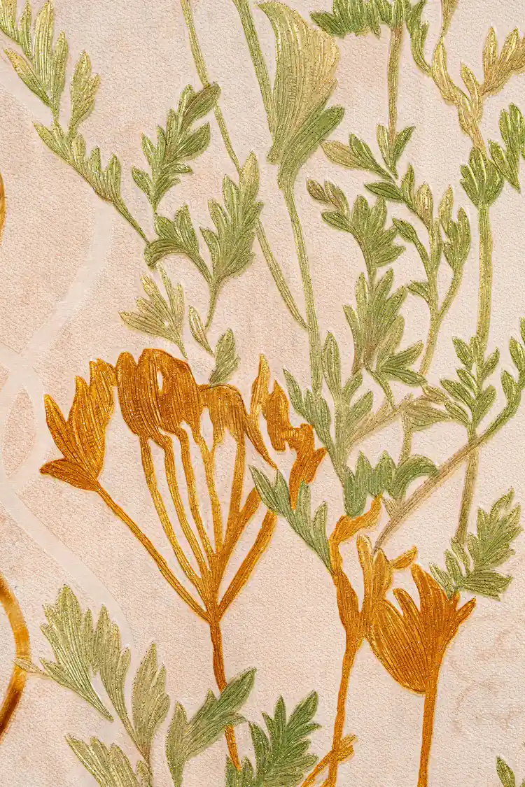 Close-up of golden fern trellis wallpaper showing green botanical stems and golden-orange flower details