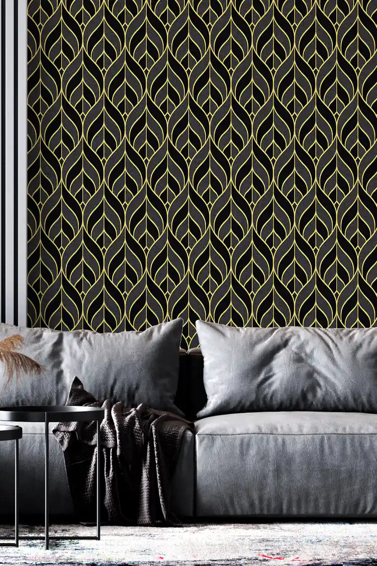 Black and gold leaf pattern wallpaper with elegant gold outlines on dark background in a modern living room with grey sofa