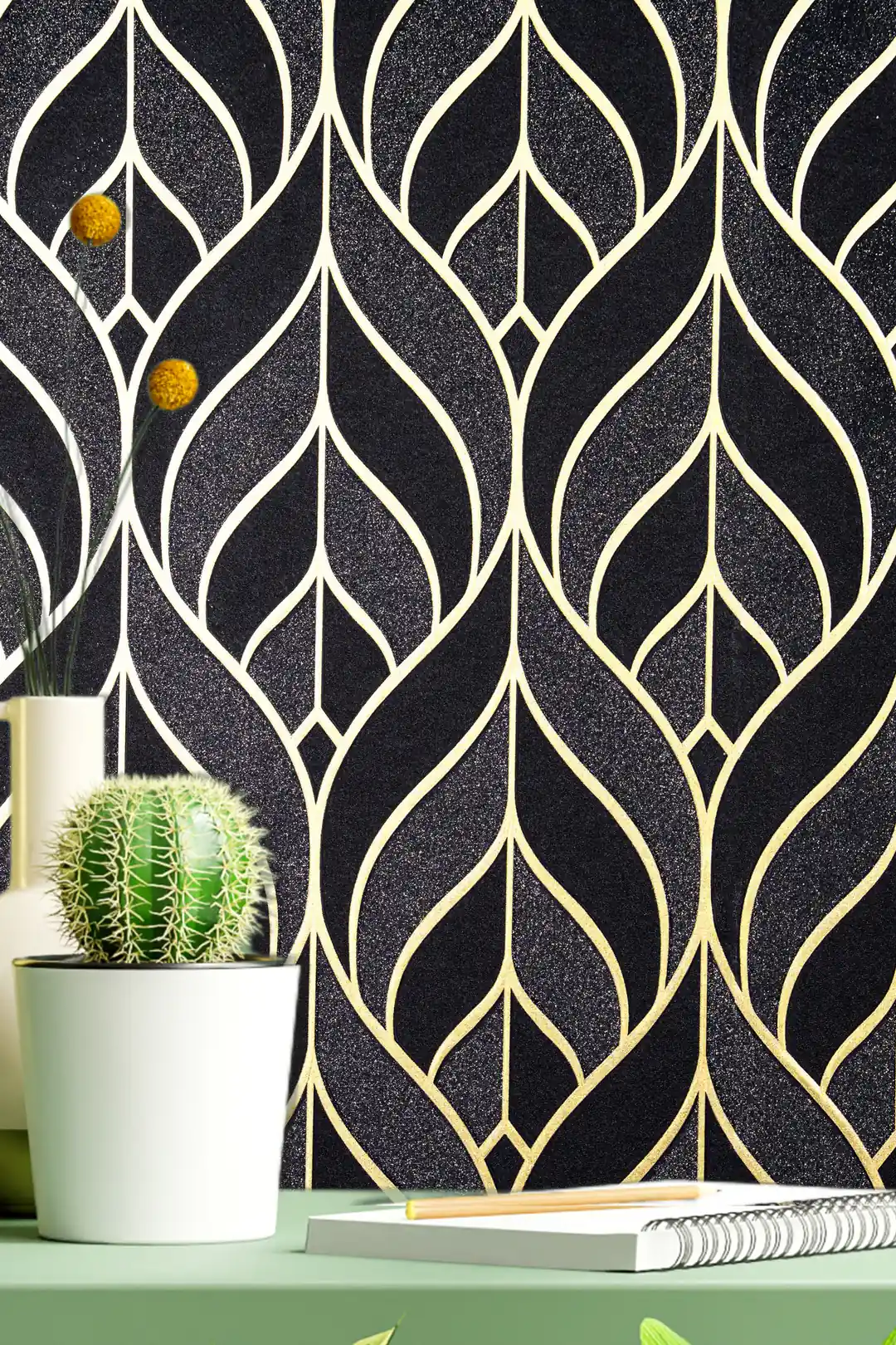 Close-up of black and gold leaf pattern wallpaper installed on wall with a cactus plant and green shelf below