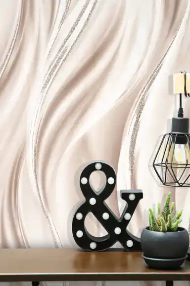 Close-up of pearl silk wave wallpaper with silver glitter lines beside a black ampersand marquee sign and industrial lamp on shelf