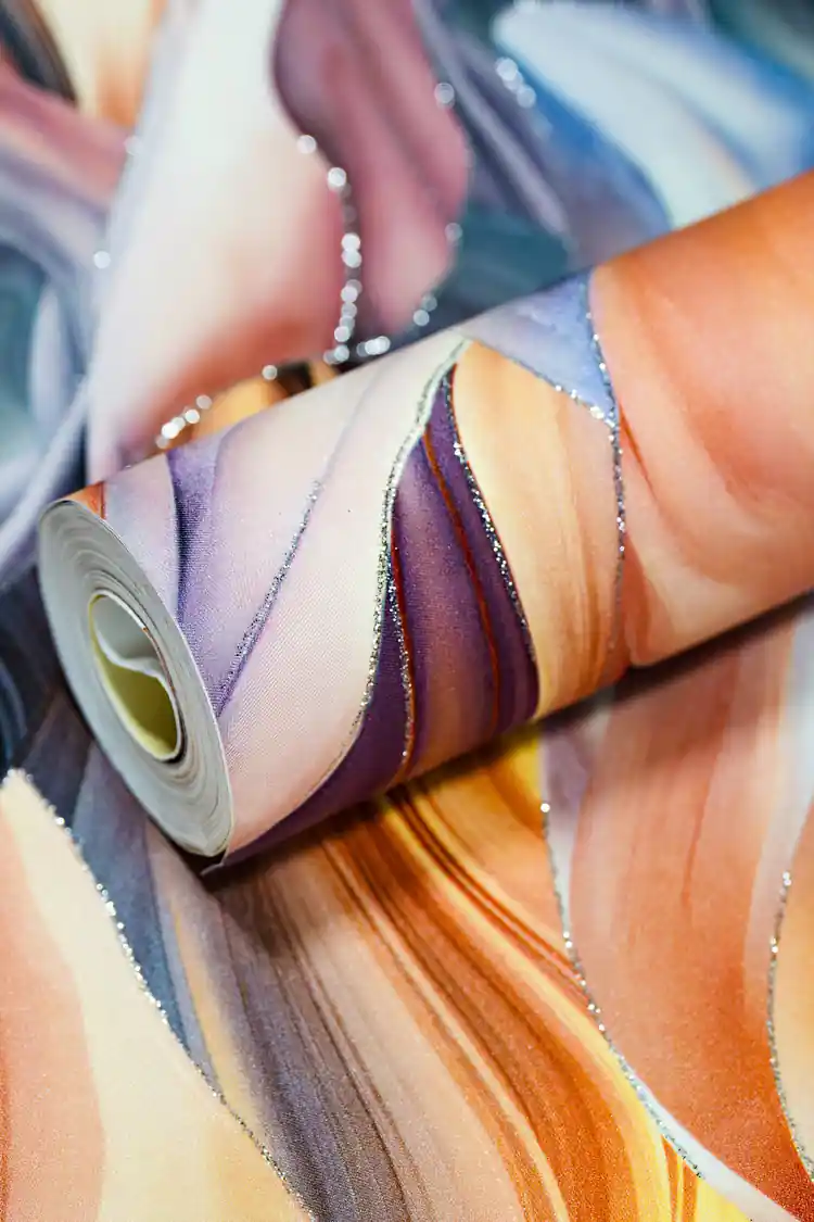 Rolled rainbow feather pattern wallpaper in warm peach, purple, and blue tones with silver glitter edges